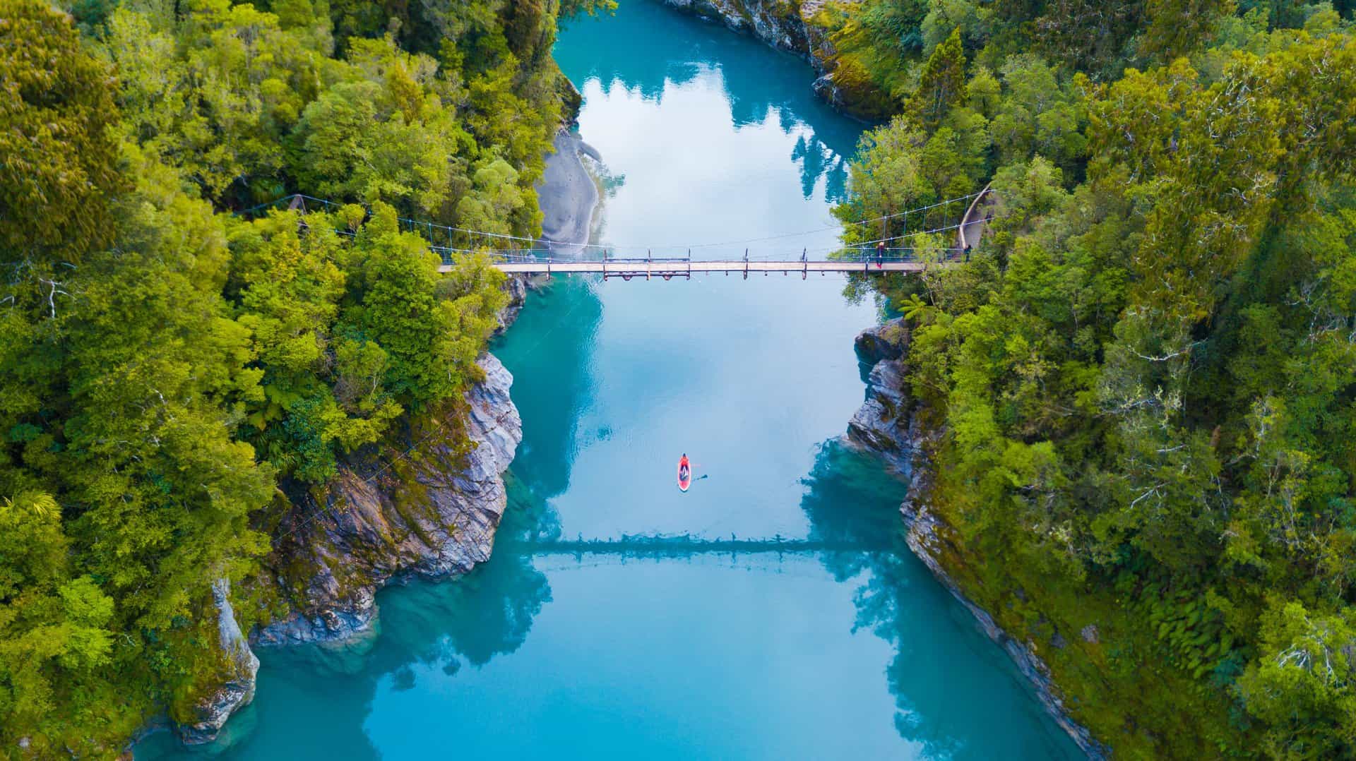Suspension Bridge At Hokitika Gorge Vibrant Blue Turquoise Water Fringed By White Granite And Ancient Rainforest